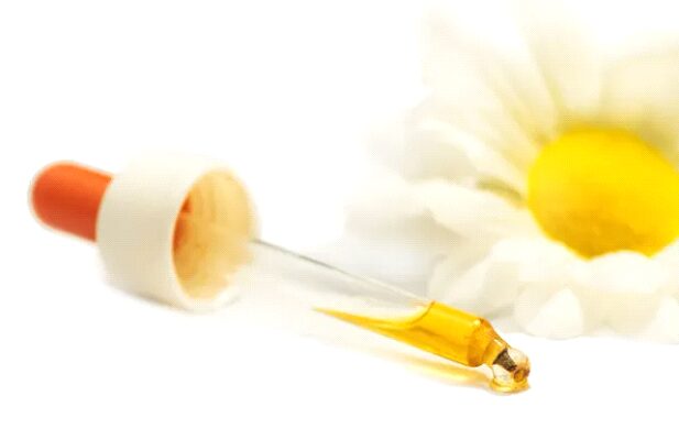 A bottle of oil sitting on top of a wooden board.