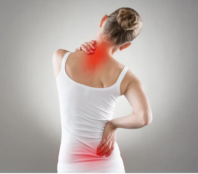 A woman with her back turned and neck in pain.