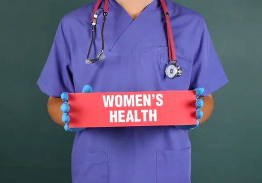 A doctor holding up a sign that says women 's health.