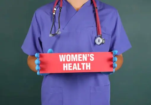 A doctor holding up a sign that says women 's health.